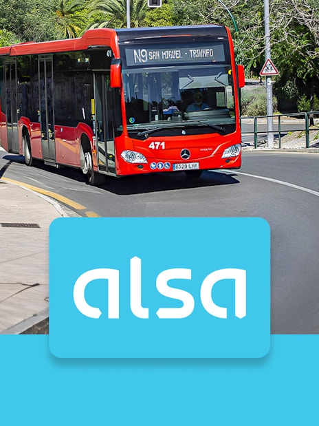 Red Alsa bus on a road in Granada, Spain, with Alsa logo in foreground.