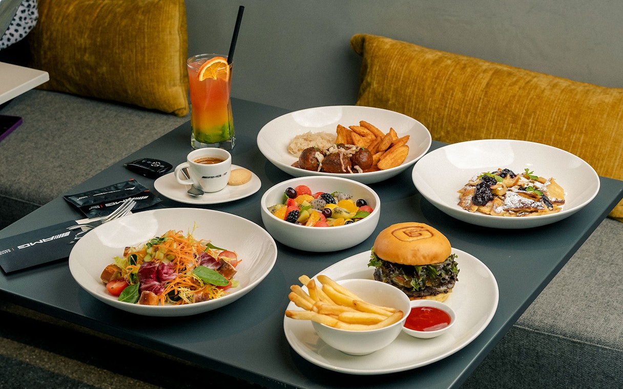 Meal selection at Mercedes-Benz Off-Road Experience Dubai with salad, burger, and dessert.