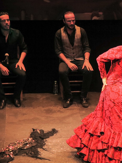 Flamenco dancer performing at Teatro Flamenco Triana with musicians.