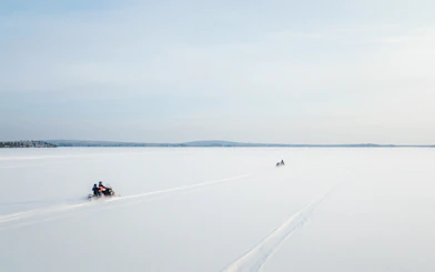 Aerial view of snowmobiles crossing a snowy landscape in Lapland.