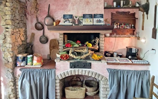 Rustic kitchen setup for pasta-making class in Alghero with ingredients and cooking tools.