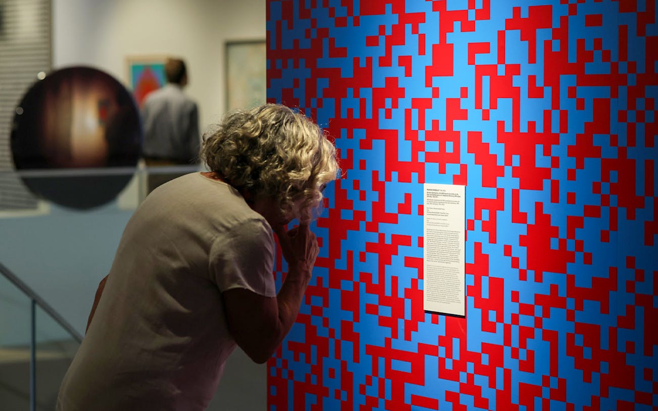 Visitor examining abstract art at Dynamic Eye Exhibition, Atkinson Museum Porto.