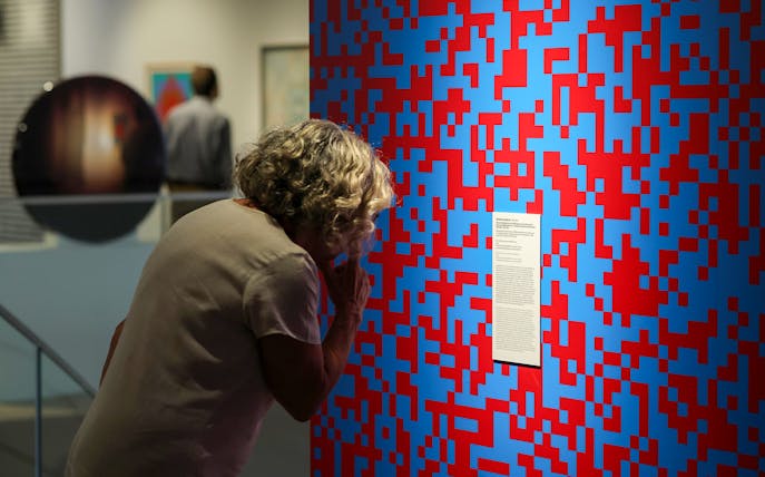 Visitor examining abstract art at Dynamic Eye Exhibition, Atkinson Museum Porto.