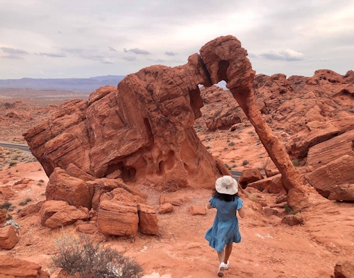 Hikers on a trail surrounded by red sandstone formations at Red Rock Canyon, Nevada.