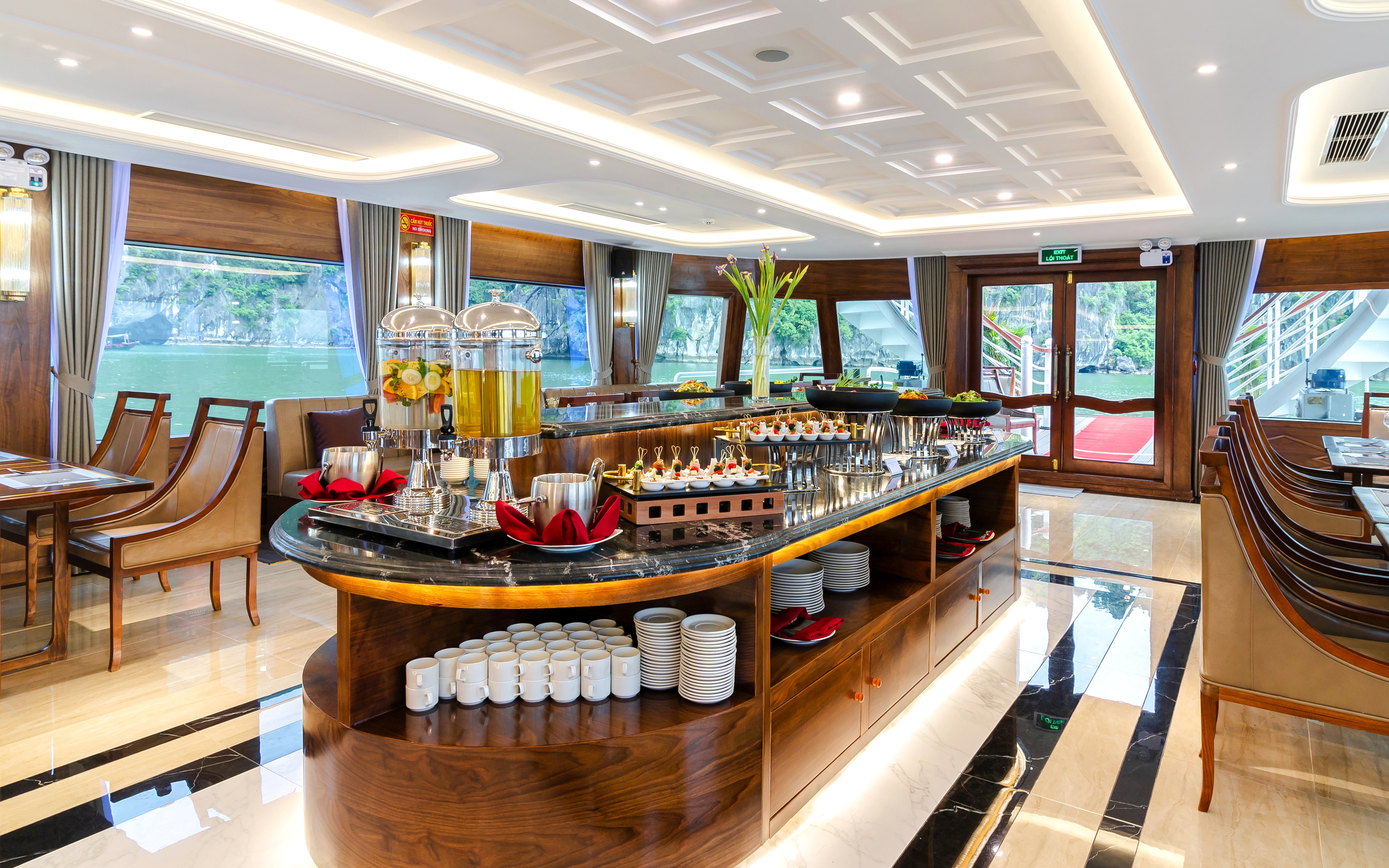 Restaurant interior on Iris Luxury Cruise, Ha Long Bay, with buffet setup and scenic window views.