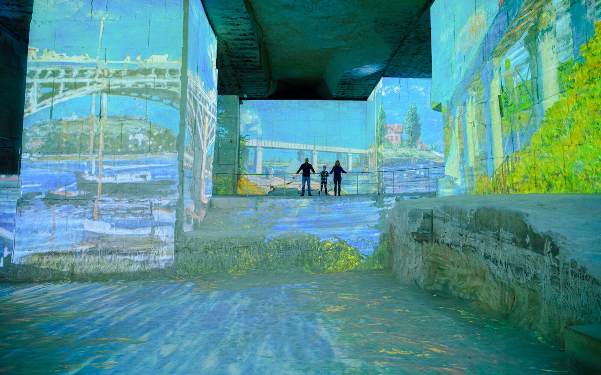 Monet projections at Carrières des Lumières with visitors viewing the immersive art display.