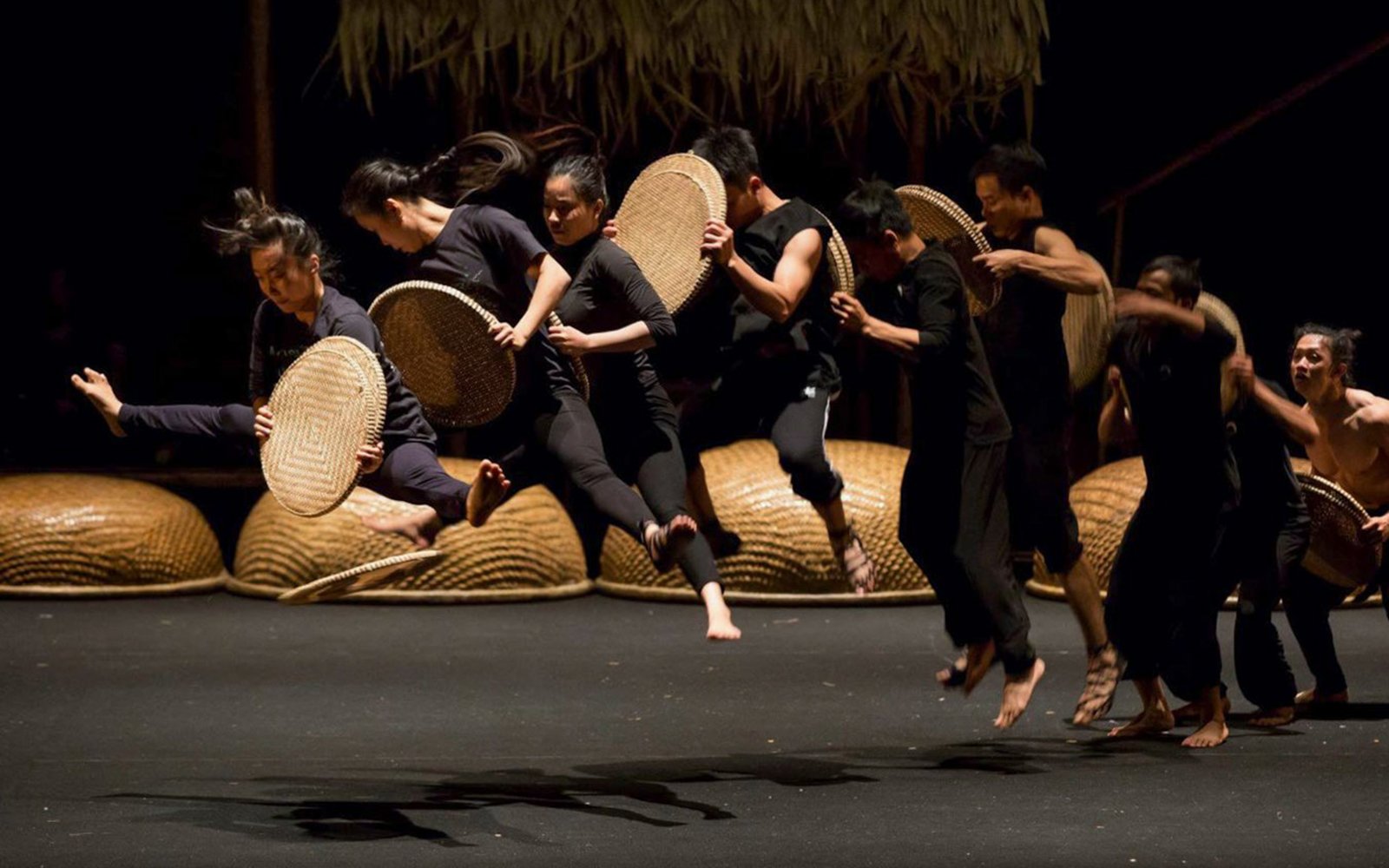 Performers with baskets leaping at A O Show circus in Vietnam.