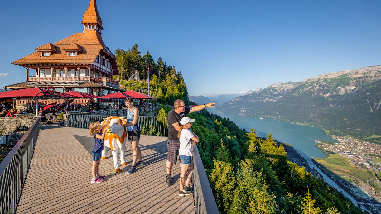 Tourists enjoying the view at Harder Kulm, overlooking Lake Brienz and the Swiss Alps.
