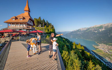 Tourists enjoying the view at Harder Kulm, overlooking Lake Brienz and the Swiss Alps.