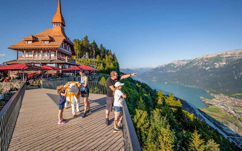Tourists enjoying the view at Harder Kulm, overlooking Lake Brienz and the Swiss Alps.