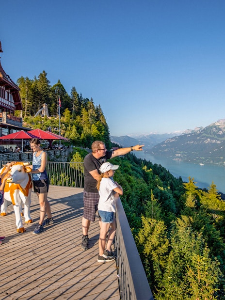 Tourists enjoying the view at Harder Kulm, overlooking Lake Brienz and the Swiss Alps.