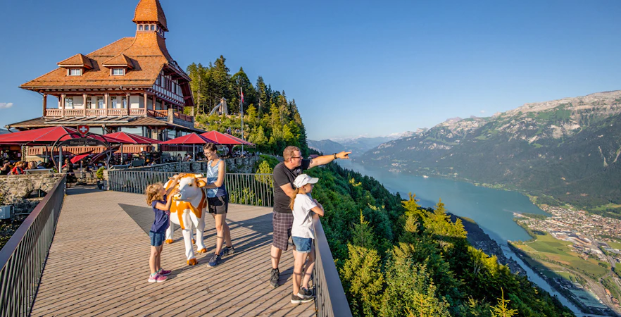 Tourists enjoying the view at Harder Kulm, overlooking Lake Brienz and the Swiss Alps.