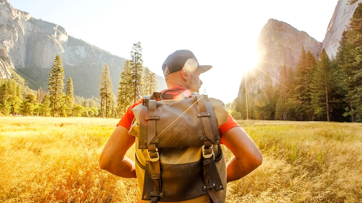 Hiker with backpack in Yosemite Valley during day tour from San Francisco.