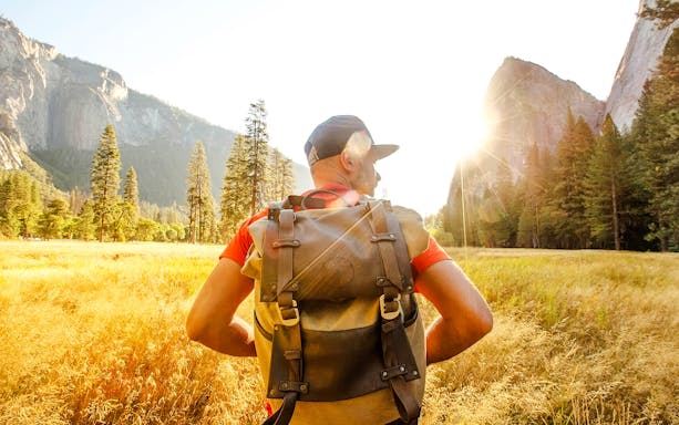 Hiker with backpack in Yosemite Valley during day tour from San Francisco.