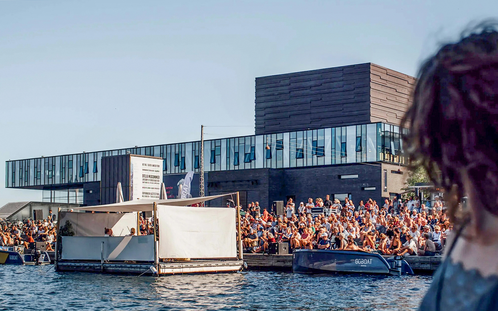 Crowd gathered by the water near The Playhouse in Copenhagen.