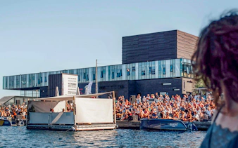 Crowd gathered by the water near The Playhouse in Copenhagen.
