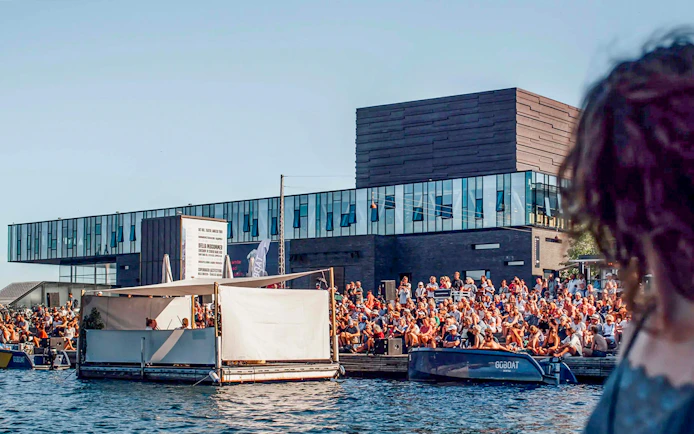 Crowd gathered by the water near The Playhouse in Copenhagen.