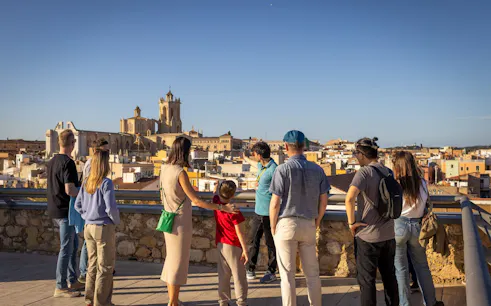 Tour group overlooking Tarragona cityscape with Roman architecture.