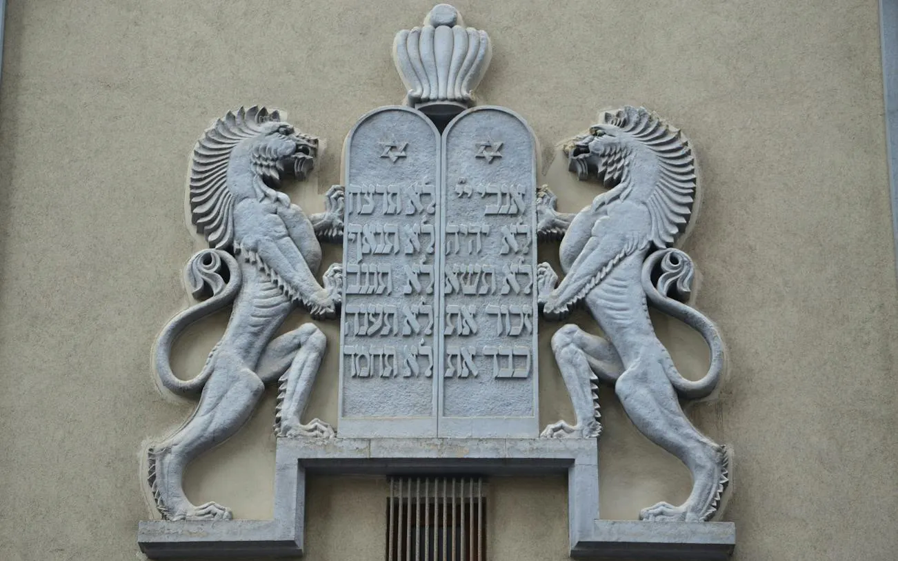 Stone relief of lions and Hebrew script on a building in Bucharest.