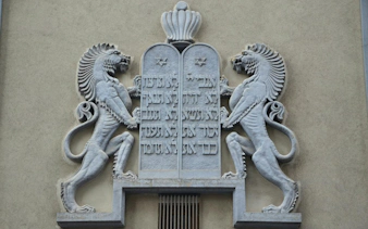 Stone relief of lions and Hebrew script on a building in Bucharest.