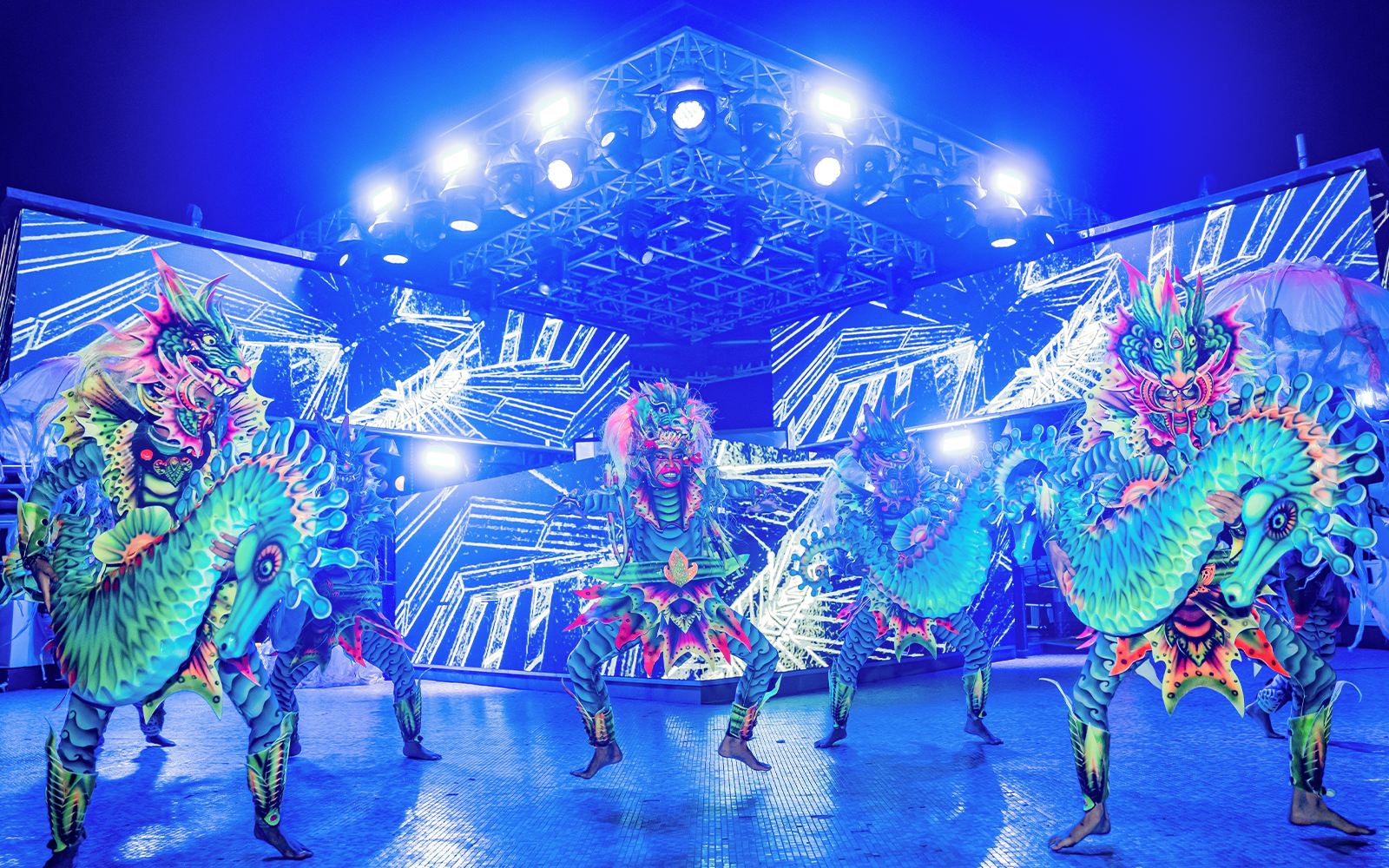 Performers in vibrant dragon costumes at Atlas Beach Club event.