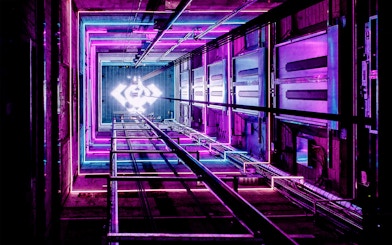 ADAM Lookout elevator shaft with vibrant neon lights in Amsterdam.