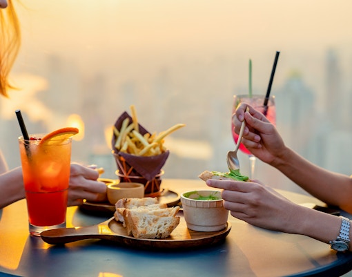 Skyline view from skyscraper restaurant with cocktail and light snack, London