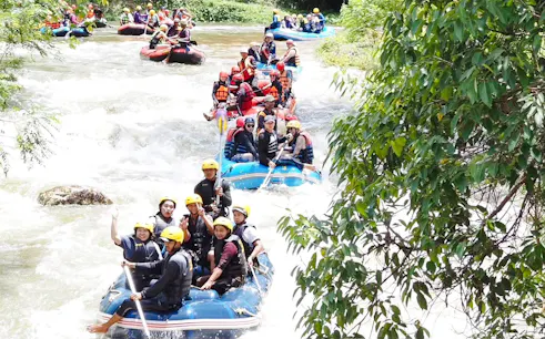 White water rafting adventure on a river in Krabi, with groups navigating rapids.