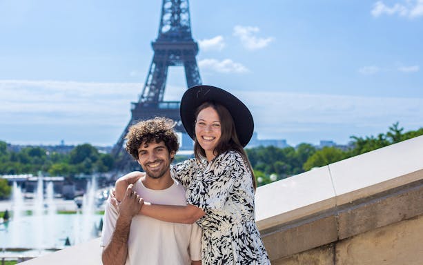 Couple posing in front of the Eiffel Tower during a private photoshoot in Paris.