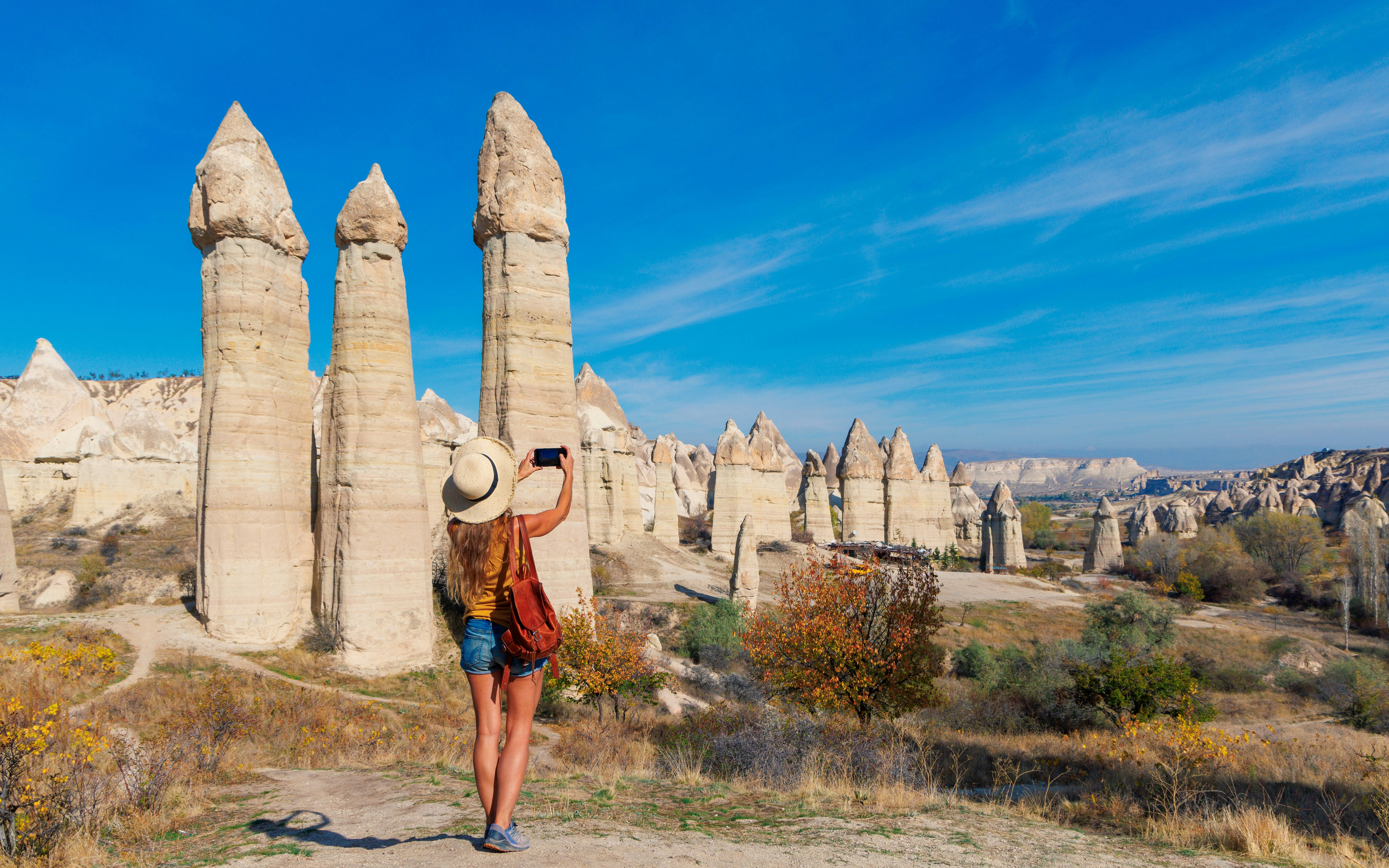 Tourist photographing rock formations in Love Valley, Cappadocia, Turkey.