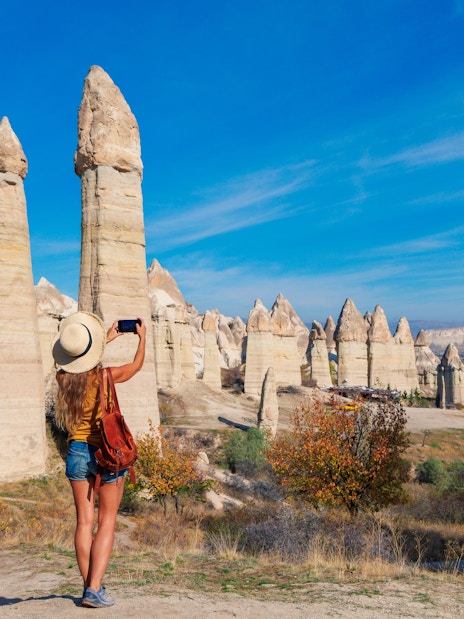 Tourist photographing rock formations in Love Valley, Cappadocia, Turkey.