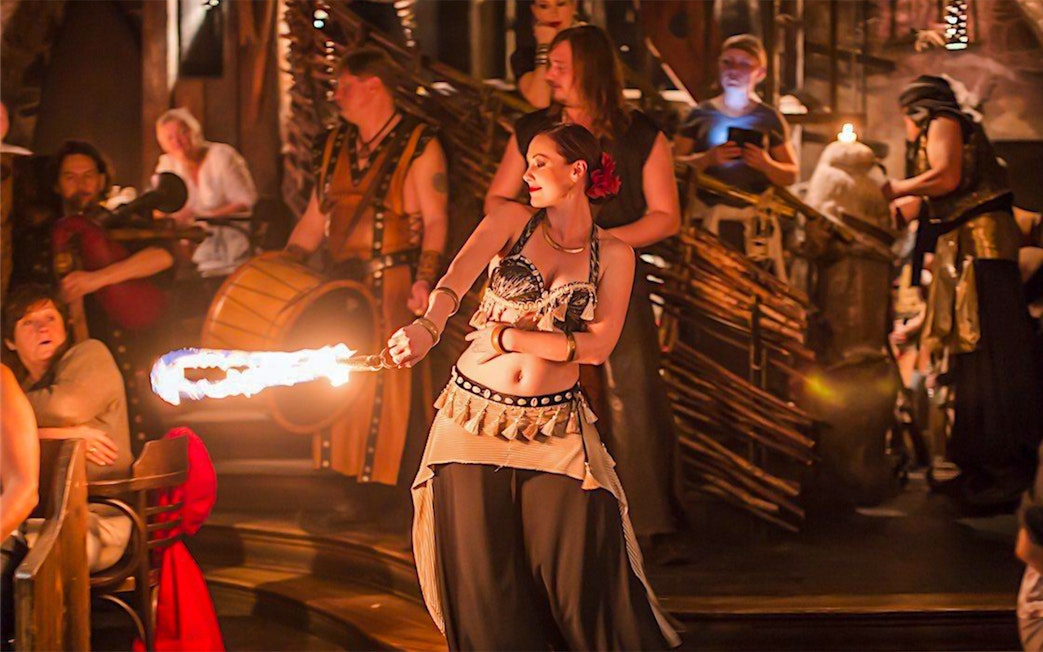 Fire performer entertaining guests at a medieval dinner show.