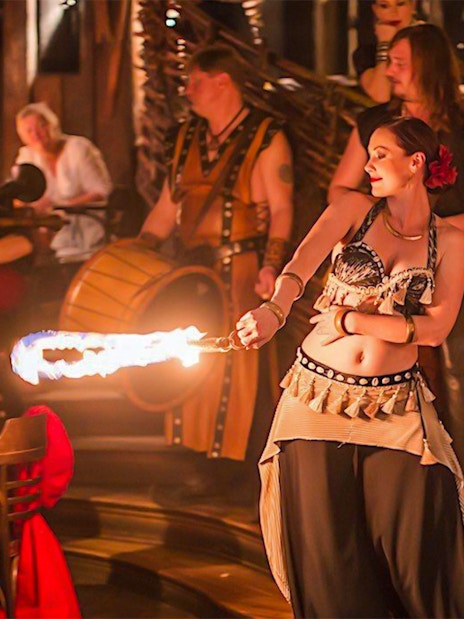 Fire performer entertaining guests at a medieval dinner show.