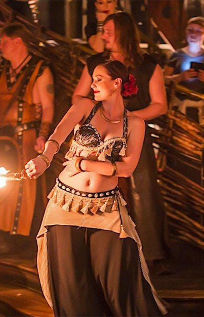 Fire performer entertaining guests at a medieval dinner show.