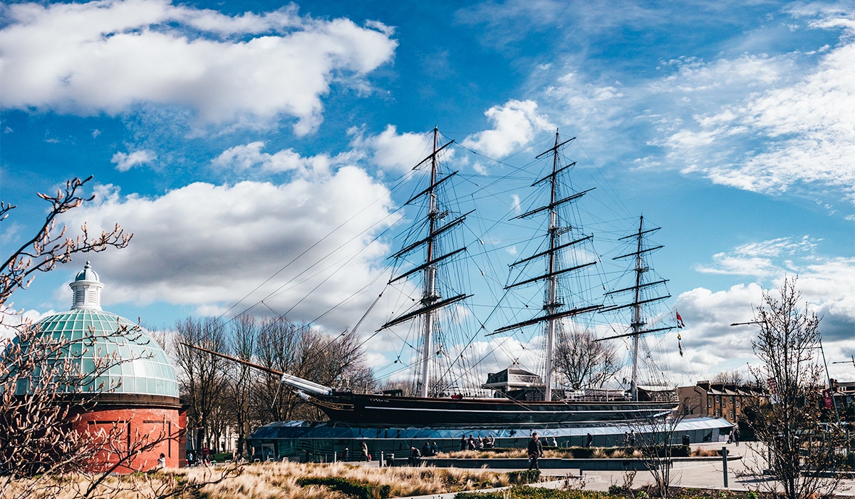 Cutty Sark ship near Royal Observatory Greenwich, London, with blue sky and clouds.