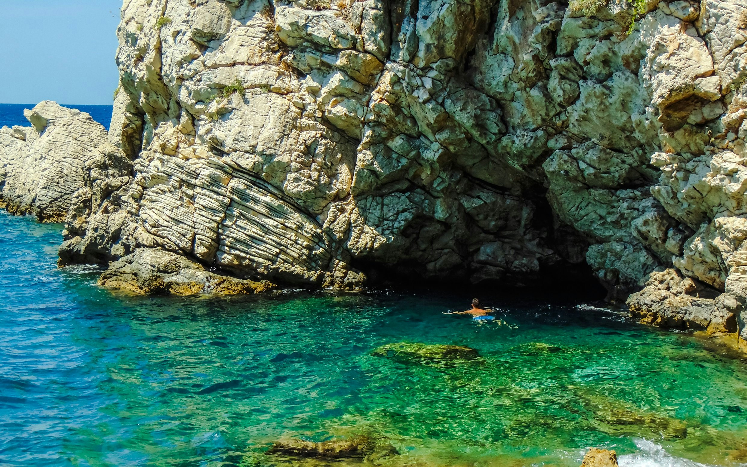 Swimming near rocky cliffs at Ksamil beaches, Saranda.