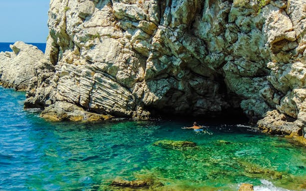 Swimming near rocky cliffs at Ksamil beaches, Saranda.