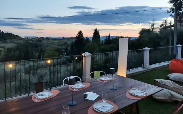 Outdoor dining setup overlooking Chianti hills at sunset during eBike tour.