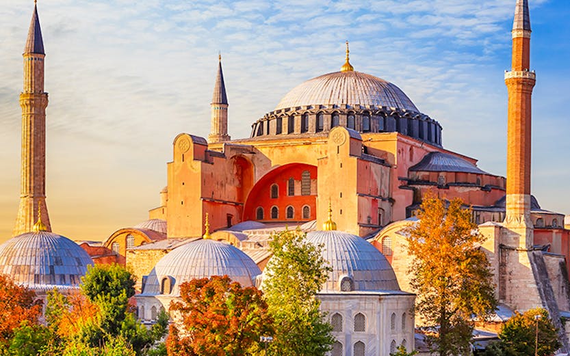 Hagia Sophia in Istanbul with minarets under a blue sky.