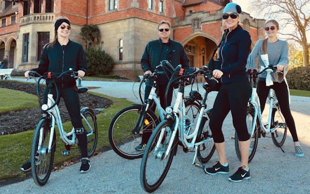 Group on bikes in front of a historic building during a guided bike tour in San Sebastian.