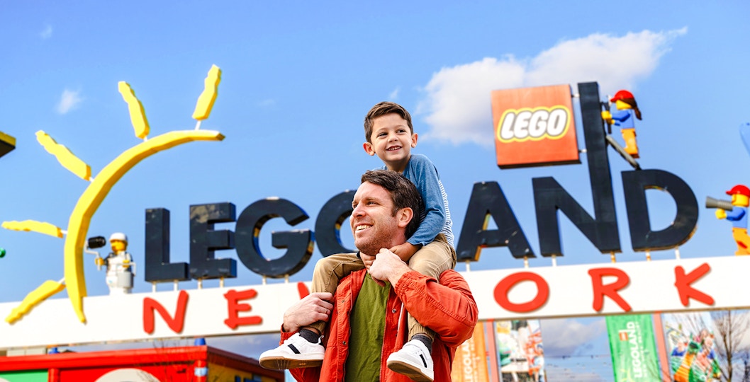 Father and son enjoying their visit at Legoland New York entrance.