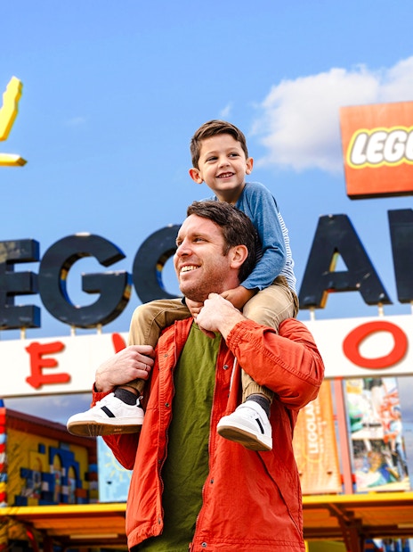 Father and son enjoying their visit at Legoland New York entrance.