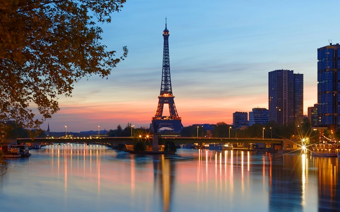 Eiffel Tower at sunset with Seine River reflections, Paris.
