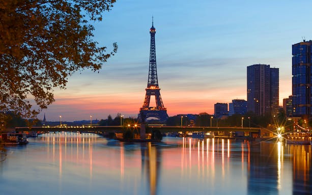 Eiffel Tower at sunset with Seine River reflections, Paris.