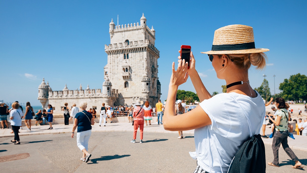 Woman taking a picture of Belem Tower
