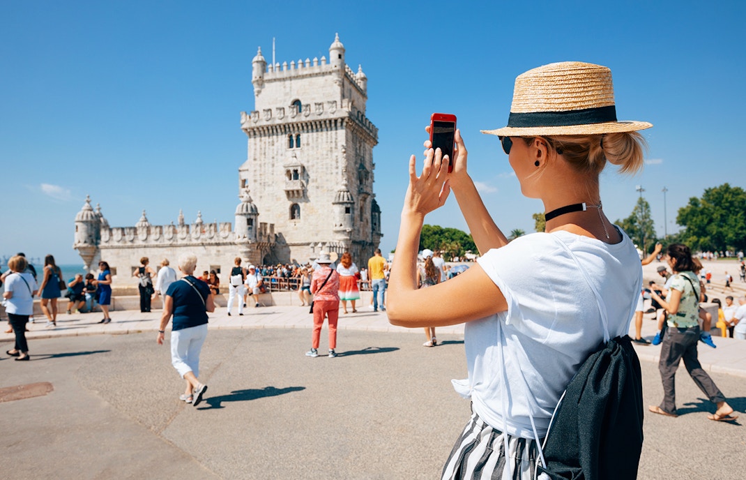 Tourist photographing Belém Tower in Lisbon, Portugal.