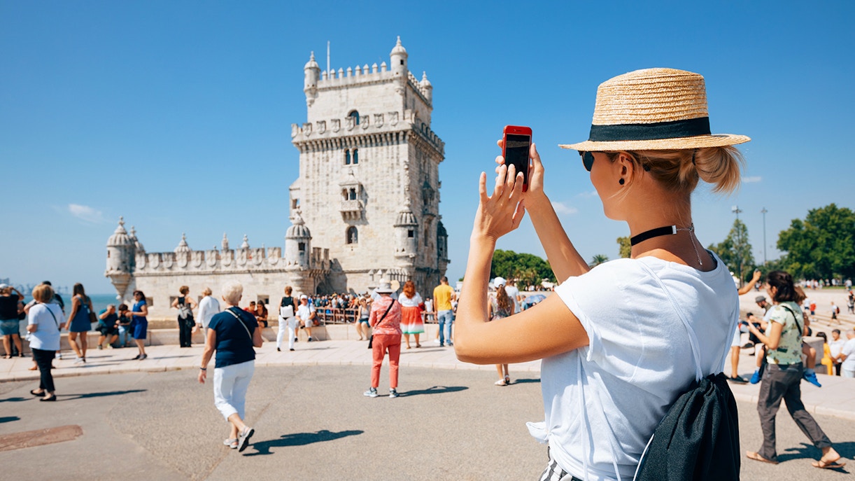 Woman taking a picture of Belem Tower