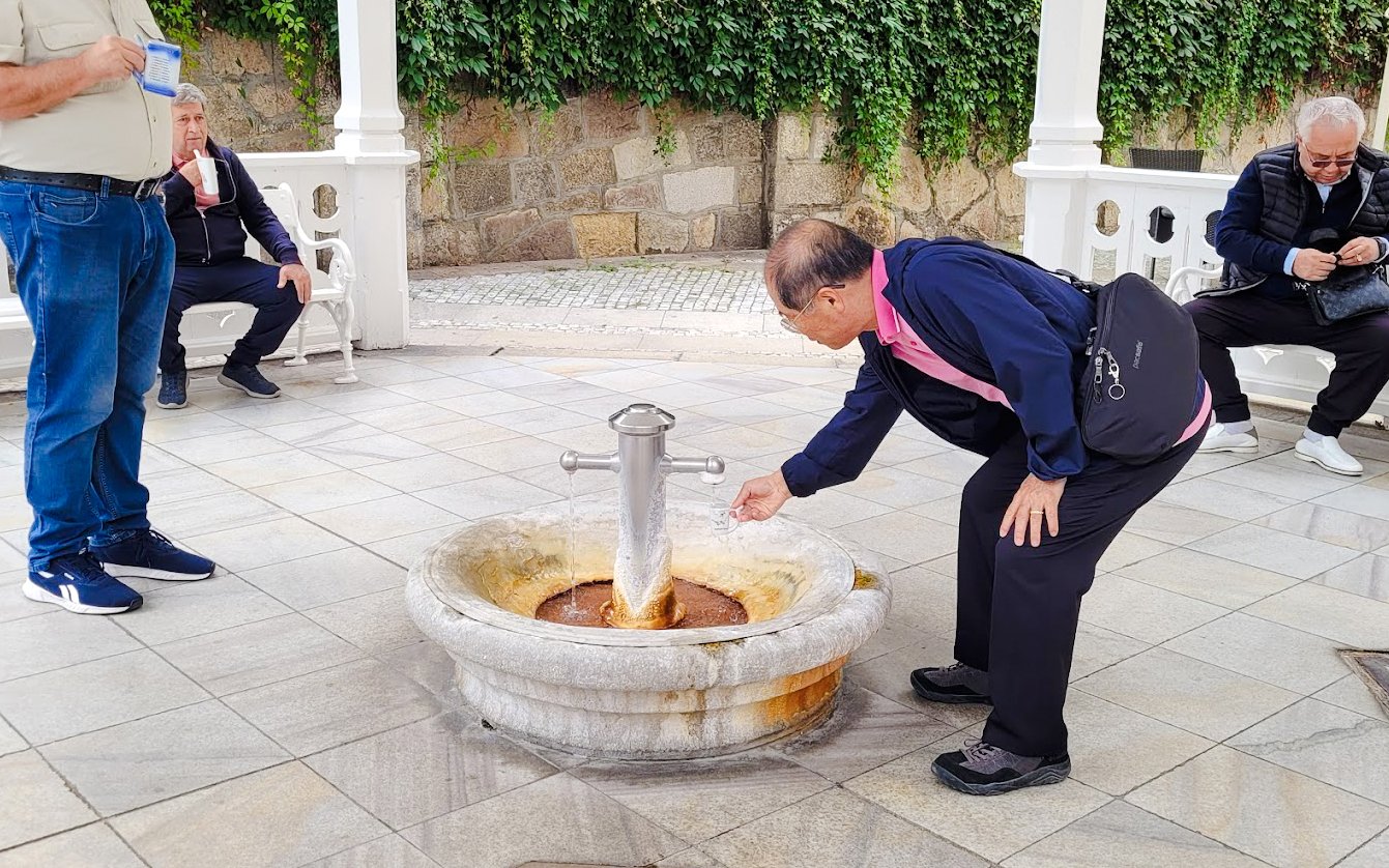Man collecting water from mineral spring in Karlovy Vary.