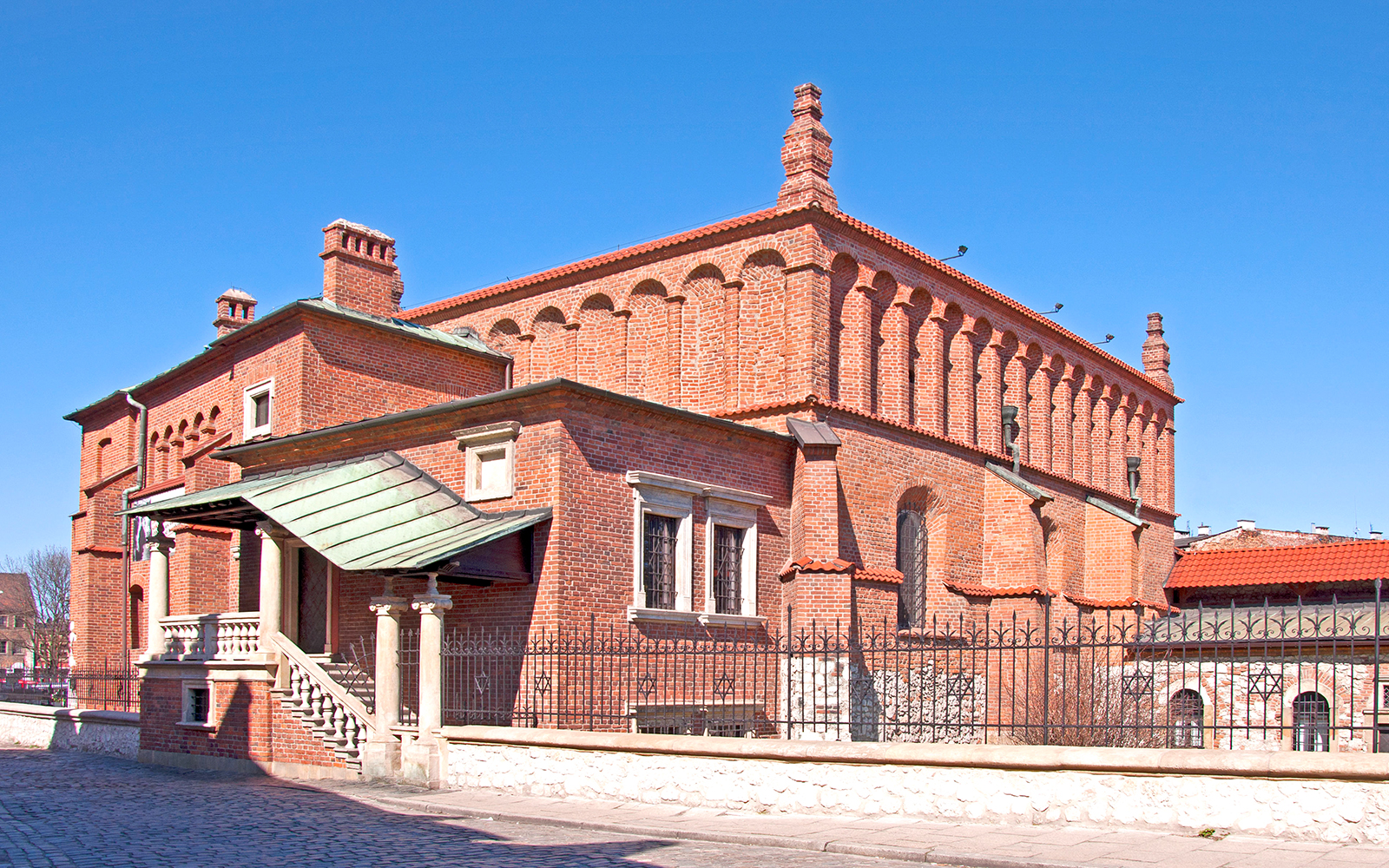 Old Synagogue in Jewish Ghetto, Krakow, with red brick architecture and arched windows.