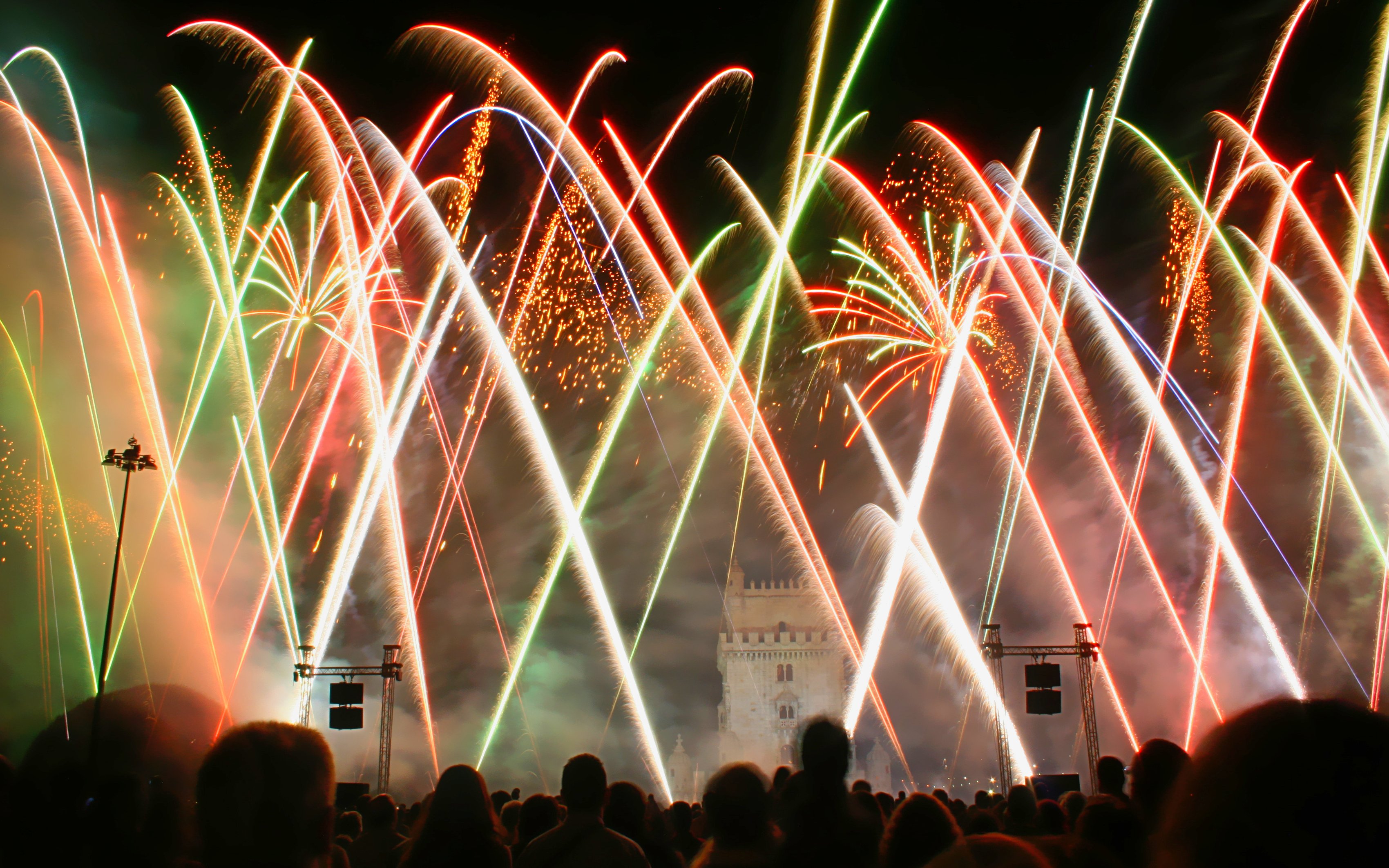 Fireworks display near Belém Tower in Lisbon at night.